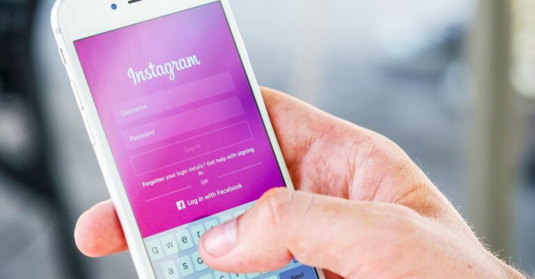Close-up of a hand holding a smartphone displaying the Instagram login screen, highlighting mobile technology.